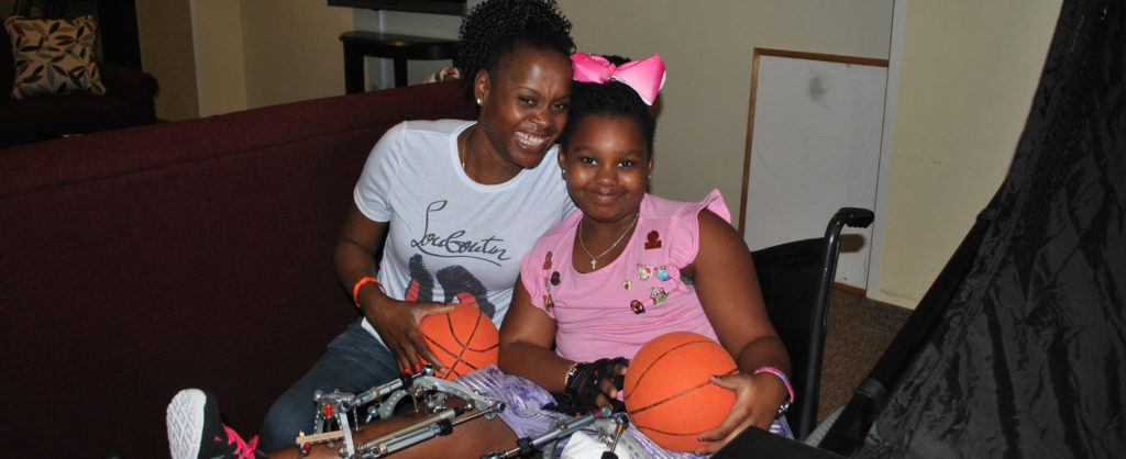Kizzy Morris and her daughter Krishanta holding basketballs that they were playing with at the Ronald McDonald House